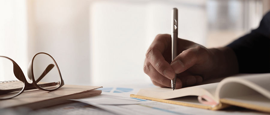 person writing on notebook