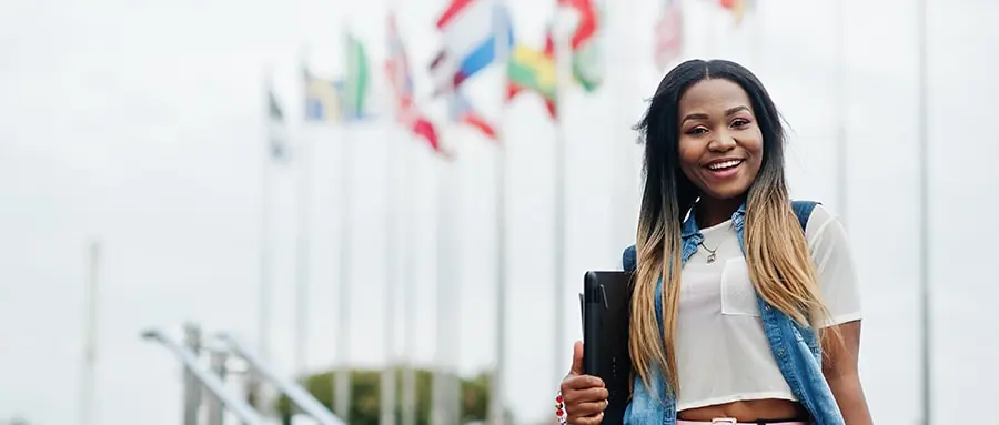 International student posing in front of flags of the world